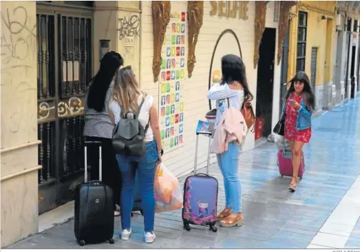  ?? JAVIER ALBIÑANA ?? Varias mujeres se disponen a entrar en una vivienda turística en el centro de Málaga.