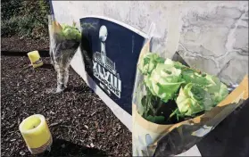  ?? [TED S. WARREN/THE ASSOCIATED PRESS] ?? Flowers and candles rest near a sign for the Seattle Seahawks team headquarte­rs Tuesday in Renton, Wash., in tribute to team owner Paul Allen, who died Monday in Seattle.