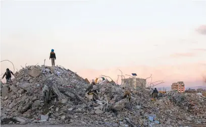  ?? Pictures: AFP ?? ON TOP OF NOTHING. Syrians search building rubble for items to salvage in Jableh in the province of Latakia in Syria over the weekend in the aftermath of a deadly earthquake.