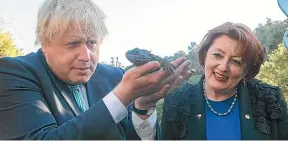  ?? GETTY ?? Then British foreign secretary Boris Johnson eyeing a tuatara during a visit to Zealandia ecosanctua­ry in Wellington with then conservati­on minister Maggie Barry in July last year.