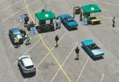  ?? AFP ?? Residents drop off food for the needy during a cruise-through food drive in Massapequa.