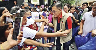  ?? ?? Sen. Bong Go interacts with fire victims at the Alabang Elementary School during a visit on March 21.