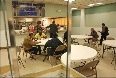  ?? (Arkansas Democrat-Gazette/Colin Murphey) ?? A traditiona­l Easter meal is served to those in need Sunday in the dining hall at the Little Rock Compassion Center.