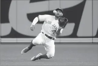  ?? DAN HAMILTON, USA TODAY SPORTS ?? Blue Jays centre-fielder Kevin Pillar makes a sliding catch on a ball hit by Seattle’s Norichika Aoki with bases loaded in the sixth inning at Rogers Centre Friday night. The Blue Jays lost 2-1.