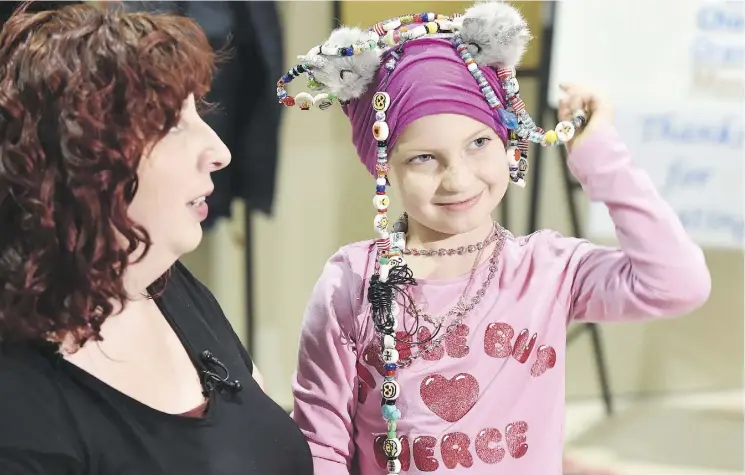  ?? ED KAISER ?? Cancer patient Nora Bazin, 7, shows off her impressive collection of beads with her mother, Emily. Canadian Blood Services is partnering with the Stollery for the January beaded journey campaign to encourage Edmontonia­ns to give blood.