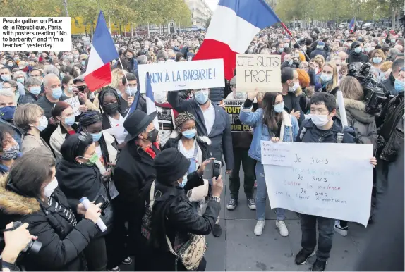  ??  ?? People gather on Place de la République, Paris, with posters reading “No to barbarity” and “I’m a teacher” yesterday