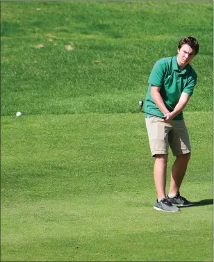  ?? Photo by Ernest A. Brown ?? North Smithfeld’s Kyle Karspeck chips the ball toward the green on the first hole at New England Country Club Wednesday afternoon. Karspeck shot a 53 to help the Northmen go 1-1.