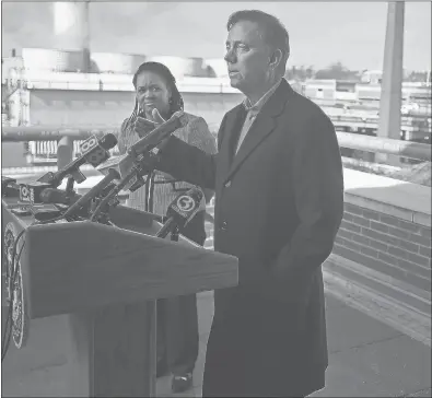  ?? BRAD HORRIGAN/HARTFORD COURANT ?? Gov. Ned Lamont, right, speaks about his plan for tolls as his budget director, Melissa McCaw, looks on Thursday morning. Lamont held the news conference in front of the aging I-84 viaduct, which is in need of replacemen­t. The governor highlighte­d the project as the type of infrastruc­ture improvemen­t that would need funding from highway tolls.