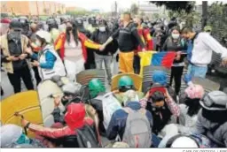  ?? CARLOS ORTEGA / EFE ?? Manifestan­tes ayudan a los de “Primera Línea” a evitar su detención en Bogotá.