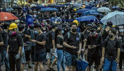  ?? LAM YIK FEI / THE NEW YORK TIMES ?? A face-off between demonstrat­ors outside a police station in Hong Kong and the police ended without violence Saturday, days after concerns were raised about spiraling mayhem.