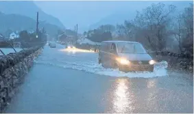  ??  ?? > Drivers in floodwater on the A4086 at Nant Peris near Llanberis