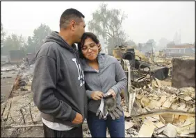  ?? AP PHOTO ?? Jose Garnica kisses his daughter Leslie in front of their home that was destroyed in the Coffey Park area of Santa Rosa, Calif.