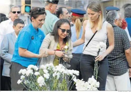  ?? ANDREU DALMAU / EFE ?? Familiares de las víctimas y afectados por el atentado terrorista del 17-A depositan claveles blancos durante el acto institucio­nal celebrado ayer.