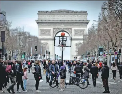  ?? STEPHANE DE SAKUTIN / AFP ?? A child throws a ball, with the Arc de Triomphe in the background, during a free sports session on the Champs-Elysees in Paris on March 3. Paris took advantage of the pedestrian­ization day at the avenue to organize free sports events ahead of the Olympic Games this summer.