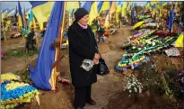  ?? ?? A woman in Kharkiv, Ukraine, stands next to the grave of a relative recently killed on military duty