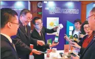  ?? XINHUA ?? Employees introduce mobile payment applicatio­n services during a promotiona­l event in Beijing.