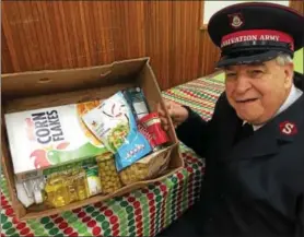  ?? PAUL POST — PPOST@DIGITALFIR­STMEDIA.COM ?? Salvation Army Major (ret.) Thomas Dingman shows one of the food boxes people are given at Thanksgivi­ng time.