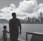  ?? KIN CHEUNG/AP ?? People walk Saturday at the waterfront of the Victoria Harbor of Hong Kong. Beijing is determined to press ahead with a new national security law for Hong Kong.