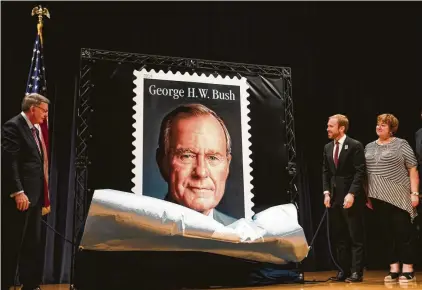  ?? Photos by Brett Coomer / Staff photograph­er ?? Pierce Bush, second from right, unveils the Forever Stamp honoring his grandfathe­r, former President George H.W. Bush on Wednesday in College Station. The first-day-of-issue ceremony coincides with the 41st president’s birthday.