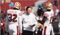  ?? Tony Avelar / Associated Press ?? San Francisco 49ers assistant Katie Sowers talks with free safety D.J. Reed (32) and wide receiver Richie James (13) before a game against the Carolina Panthers in 2019.