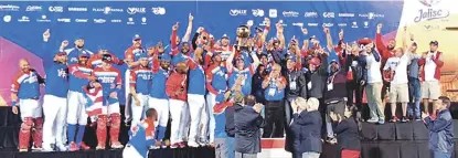  ??  ?? Jugadores, entrenador­es y fanáticos de los Criollos de Caguas celebran tras recibir la copa de campeones de la Serie del Caribe.