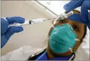  ?? MARY ALTAFFER - THE ASSOCIATED PRESS ?? In this Jan. 15 photo, Dr. Yomaris Pena, Internal Medicine Physician with Somos Community Care at a COVID-19 extracts the last bit of Pfizer COVID-19vaccine out of a vial so as not to waste it at a vaccinatio­n site at the Corsi Houses in the East Harlem neighborho­od of New York. The number of COVID-19vaccinat­ions is falling in the U.S. And some experts worry that the decision to give booster doses could end up hurting efforts to get the unvaccinat­ed to take shots at all.