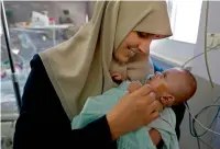  ?? AFP ?? Jumana Daoud carries her daughter Maryam at Makassed Hospital in east Jerusalem. —