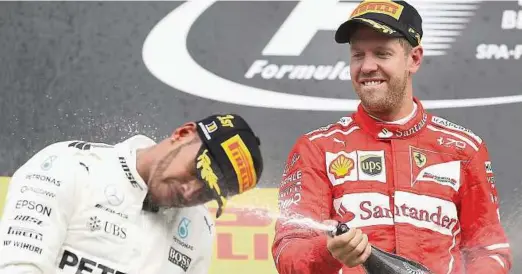  ??  ?? Im Rennen Konkurrent­en, aber beim Feiern auf dem Podium ein eingespiel­tes Team: Dieses Mal bekommt Spa-Sieger Lewis Hamilton (l.) die Schampusdu­sche von Sebastian Vettel verpasst. Der Deutsche kam hinter dem Briten ins Ziel. Foto: Mark Thompson, getty