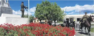  ?? PHOTO: PAM JONES ?? Poppies of remembranc­e . . . Members of the New Zealand Mounted Rifles Charitable Trust lead a ‘‘100 horse’’ parade past Alexandra’s war memorial yesterday. The Mounted Rifles were joined by other Central Otago adult and pony club riders in the parade, which was followed by a service in Pioneer Park and Mounted Rifle Games.