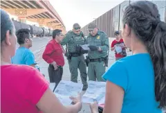  ??  ?? PAPERS PLEASE: US Border Protection agents check documents of a group of migrants, who crossed the Rio Grande from Juarez, Mexico in El Paso, Texas.