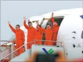  ?? FANG ZHE / XINHUA ?? Crew members of the C919, China’s first homegrown large passenger plane, wave at spectators in Shanghai on May 5 after the plane completed its first test flight.