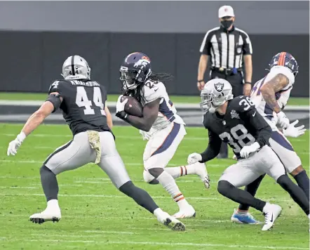  ?? Photos by Andy Cross, The Denver Post ?? Broncos running back Melvin Gordon tries to get through the defense of Raiders inside linebacker Nick Kwiatkoski ( 44) and strong safety Jeff Heath ( 38) in the first quarter at Allegiant Stadium on Sunday.