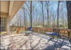  ??  ?? A spacious back deck overlooks the level, parklike backyard, which is adjacent to a walking trail.