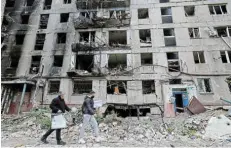  ?? Picture: ALEXANDER ERMOCHENKO/ REUTERS ?? REFERENDUM UNDER WAY: Members of an electoral commission carry a mobile ballot box as they walk past a destroyed building in Mariupol, Ukraine, at the weekend