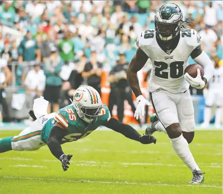  ?? JASEN VINLOVE/USA TODAY SPORTS ?? Eagles running back Jay Ajayi outruns diving Dolphins linebacker Jerome Baker during Philadelph­ia’s 37-31 loss to Miami on the weekend. The Eagles fell to 5-7 with the loss, but could still prevail in the weak NFC East Division, thus earning a home playoff date.