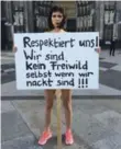  ??  ?? Artist Milo Moire holds a sign "Respect us! We are not fair game even when we are naked!!!" as she protests in Cologne on Friday.