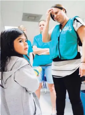  ?? AFP ?? La pequeña Jenquel entró a Estados Unidos con su madre y hermanos. En la foto, con voluntario­s de un albergue en McAllen, Texas.