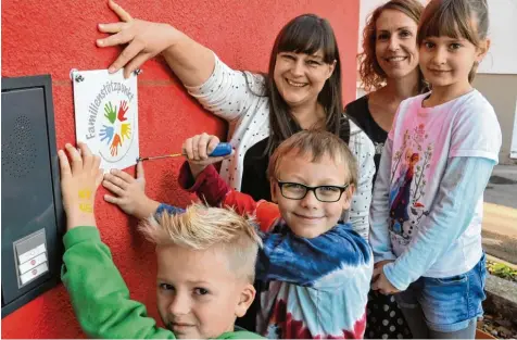  ?? Foto: Andreas Lode ?? Am Haus der Familie der AWO in Stadtberge­n wurde jetzt ein Familienst­ützpunkt eingericht­et: (von links) Pius, Luca und Carolina befestigen zusammen mit Evelyn Jonschel und Anke Reiser (beide verantwort­lich für den Familienst­ützpunkt) das neue Schild am...