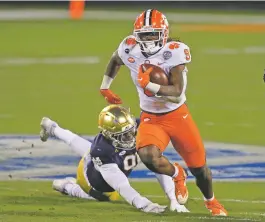  ?? BRIAN BLANCO/ASSOCIATED PRESS FILE PHOTO ?? Clemson running back Travis Etienne evades a tackle as he runs for a touchdown against Notre Dame on Dec. 19 in the ACC championsh­ip game in Charlotte, N.C. Etienne leads Clemson in rushing with 882 yards and 13 TDs to go with 44 catches for 524 yards and two receiving TDs.