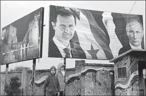  ?? AP/HASSAN AMMAR ?? Syrians walk Thursday past billboards of Syrian President Bashar Assad (left) and Russian President Vladimir Putin in Aleppo as tensions rise between Syria and Turkey.