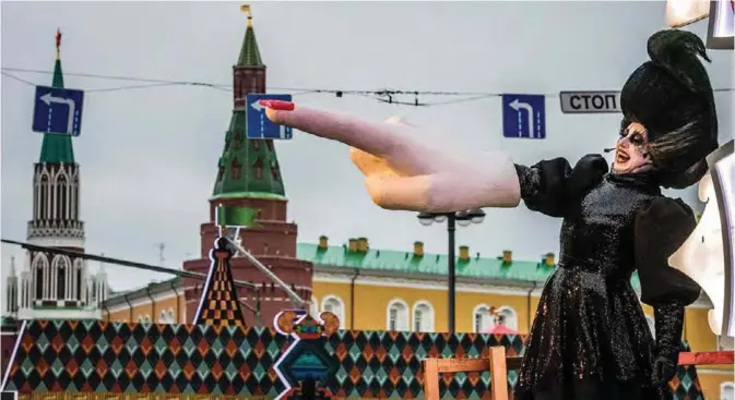  ??  ?? A street performer points with a giant hand on Tverskaya street in front of the Kremlin during a festival marking the New Year and Christmas in central Moscow yesterday. Russia celebrates the Orthodox Christmas on January 7th.