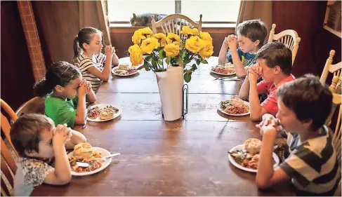  ??  ?? Los hijos de summer mossbarger dan las gracias antes de cenar