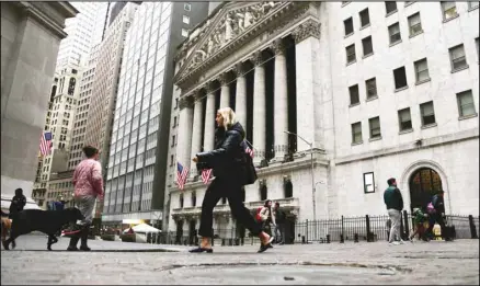  ?? ?? People pass the front of the New York Stock Exchange in New York, on Wednesday, March 22, 2023. European shares have opened mixed after a day of gains in Asia ahead of a decision by the Federal Reserve on interest rates. (AP)