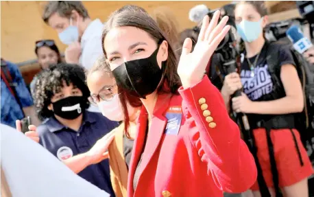  ?? CHINA DAILY ?? US Congresswo­man Alexandria Ocasio-Cortez waves as she makes a stop to greet voters during the Democratic congressio­nal primary election in the Queens borough of New York City, New York, US.