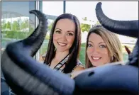  ?? Arkansas Democrat-Gazette/JOHN SYKES JR. ?? Lindsay Carter (left) of The Van and Mandy Brown of Family Promise of Pulaski County take the bull by the horns as organizers of Saturday’s The Running of the Bulls de La Pequna Roca, to raise money for the homeless.