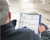  ??  ?? A member of Columbus Gay Men’s Chorus reads sheet music arranged by artistic director Brayton Bollenbach­er during a rehearsal in preparatio­n for their first performanc­e of the season.