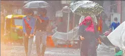  ?? HT PHOTO ?? People walk with umbrellas amid heavy showers near Jama Masjid in New Delhi on Sunday.