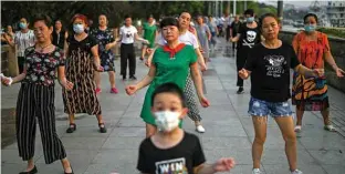  ??  ?? People dancing during the afternoon next to the Yangtze River in Wuhan in China’s central Hubei province. — AFP photos