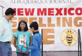  ?? MARLA BROSE/JOURNAL ?? Flanked by her father, Nanda Kumar, left, and her brother, Anirude Nanda, Akansha Nanda, center, holds her trophy after winning last year’s New Mexico Spelling Bee. She placed 42nd in the Scripps National Spelling Bee. Both Akansha and Anirude are competing again this year.