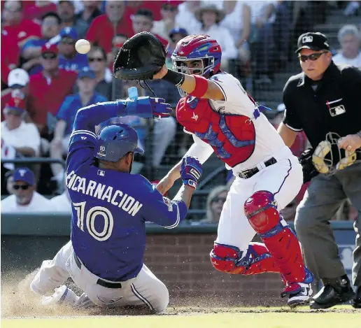  ?? Tom Pennington / Gett
y Images ?? Edwin Encarnacio­n slides home safely before catcher Robinson Chirinos of the Texas Rangers can apply the tag in the third inning Monday of Game 4 of the American League Division Series at Globe Life Park in Arlington, Tex.